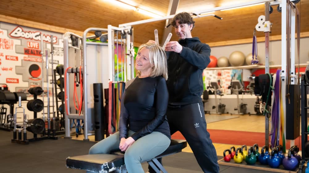 A wellness evaluation where the trainer is measuring the angle of the client’s neck